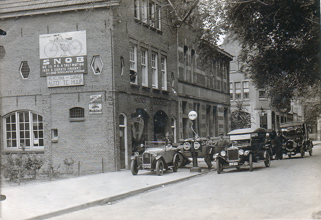 Wilhelminagarage te Vlissingen aan de Wilhelminastraat. Achter het stuur Marietje van den Heuvel, achter de auto vader Leendert van den Heuvel en boven uit het raam zijn vrouw Maria Johanna de Waal. Wilhelminagarage te Vlissingen aan de Wilhelminastraat. Achter het stuur Marietje van den Heuvel, achter de auto vader Leendert van den Heuvel en boven uit het raam zijn vrouw Maria Johanna de Waal.